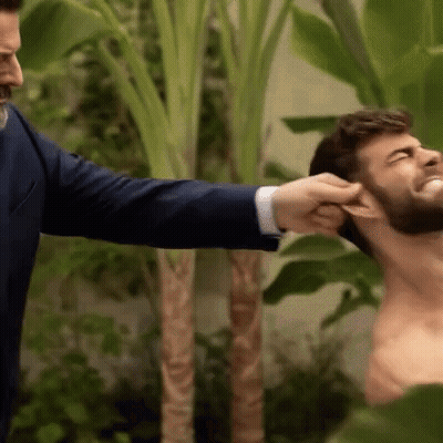 A Man In A Suit Is Putting His Hand On A Man 'S Ear . GIF