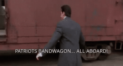 A Man In A Suit Is Running Towards A Train With The Words Patriots Bandwagon All Aboard Written On The Bottom GIF