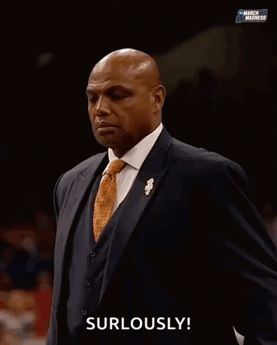 A Man In A Suit Is Saying " Surlously " In Front Of A Crowd GIF