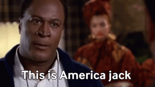 A Man In A Suit Is Saying This Is America Jack In Front Of A Woman In A Red Dress . GIF