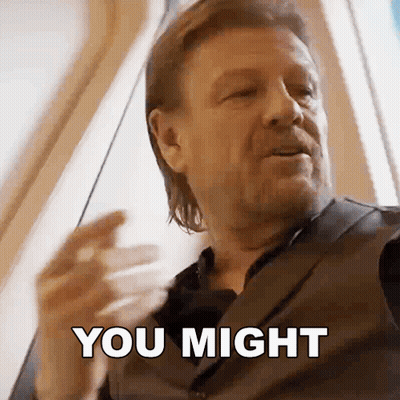 A Man In A Suit Is Saying You Might With His Hand GIF
