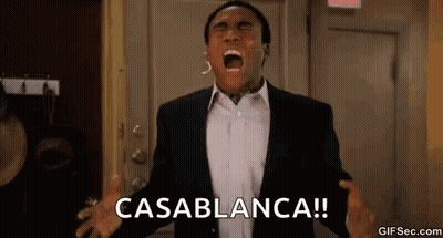 A Man In A Suit Is Screaming In Front Of A Door With His Mouth Open . GIF