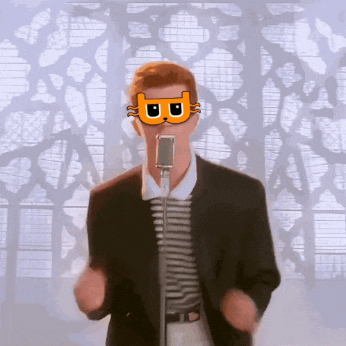 A Man In A Suit Is Singing Into A Microphone With A Cat Mask On His Face GIF