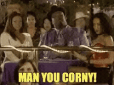 A Man In A Suit Is Sitting At A Table With A Group Of Women And Says Man You Corny . GIF