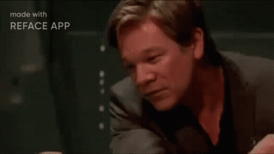 A Man In A Suit Is Sitting At A Table With His Head Resting On His Hand . GIF