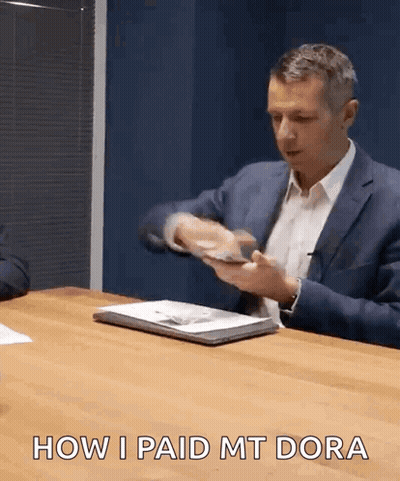 A Man In A Suit Is Sitting At A Table With The Words How I Paid Mt Dora GIF