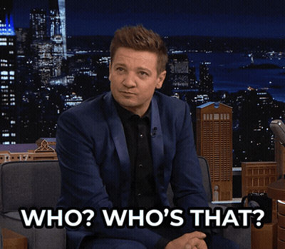 A Man In A Suit Is Sitting In A Chair And Says " Who Who 'S That " GIF