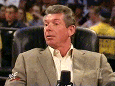 A Man In A Suit Is Sitting In A Chair With A Microphone In Front Of Him GIF