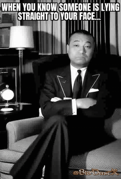 A Man In A Suit Is Sitting In A Chair With His Arms Crossed . GIF