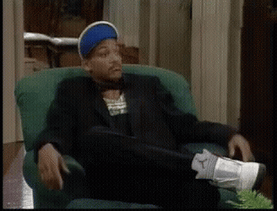 A Man In A Suit Is Sitting In A Chair With His Feet Up GIF