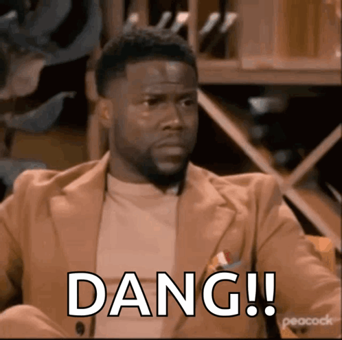 A Man In A Suit Is Sitting In A Chair With The Word Dang Written On His Face . GIF
