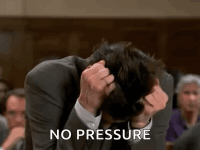 A Man In A Suit Is Sitting In A Courtroom Holding His Head . GIF