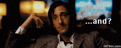 A Man In A Suit Is Sitting In A Dark Room With The Words " And " On The Bottom GIF