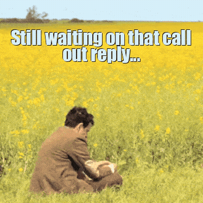 A Man In A Suit Is Sitting In A Field Of Yellow Flowers With A Caption That Says Still Waiting On That Call Out Reply GIF