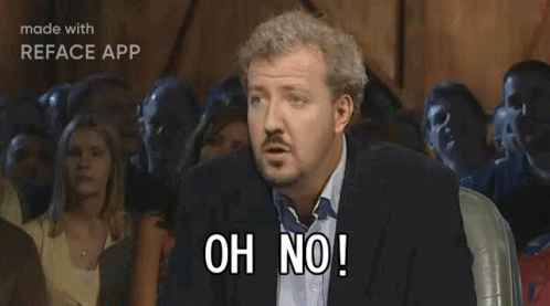 A Man In A Suit Is Sitting In Front Of A Crowd And Says Anyway GIF