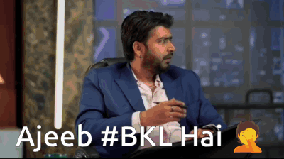 Man In Suit In Front Of Ajeeb Sign GIF