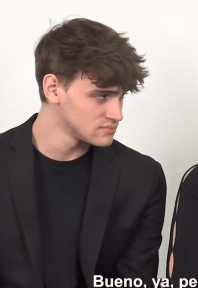 A Man In A Suit Is Sitting Next To A Woman And Says Bueno GIF