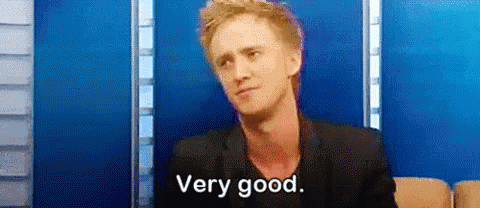 A Man In A Suit Is Sitting On A Couch And Saying `` Very Good '' . GIF