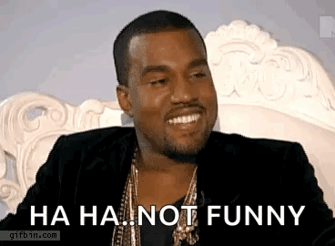 A Man In A Suit Is Sitting On A Couch And Smiling . GIF