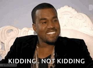 A Man In A Suit Is Sitting On A Couch And Smiling While Saying `` Kidding , Not Kidding '' . GIF