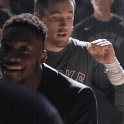 A Man In A Suit Is Smiling And Looking At Another Man GIF