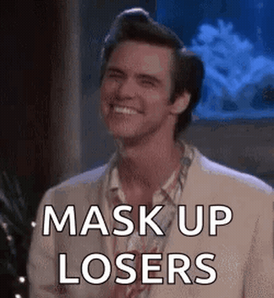A Man In A Suit Is Smiling And Saying `` Mask Up Losers '' In Front Of An Aquarium . GIF