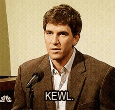 A Man In A Suit Is Speaking Into A Microphone And Says Kewl GIF