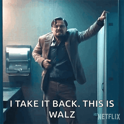 A Man In A Suit Is Standing In A Bathroom With The Words I Take It Back This Is Walz GIF