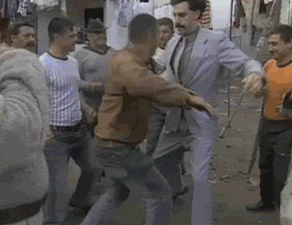 A Man In A Suit Is Standing In A Crowd Of People GIF