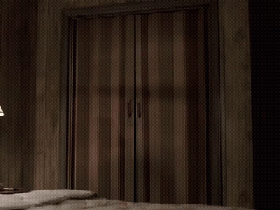 A Man In A Suit Is Standing In A Doorway GIF