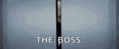 A Man In A Suit Is Standing In A Doorway With The Words The Boss Written On It . GIF