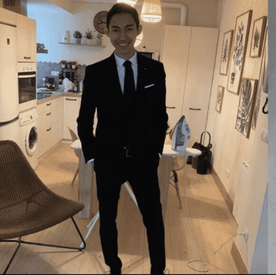 A Man In A Suit Is Standing In A Kitchen With His Hands In His Pockets GIF