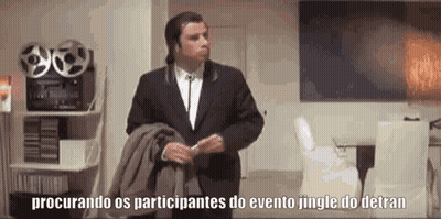 A Man In A Suit Is Standing In A Living Room Holding A Jacket And A Blanket . GIF
