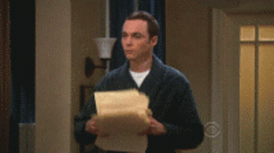 A Man In A Suit Is Standing In A Living Room With Papers Falling From The Ceiling GIF