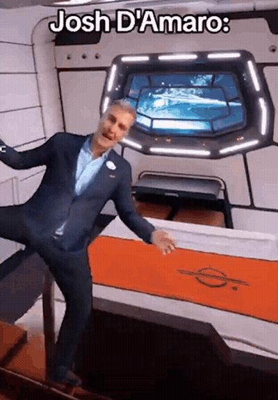 A Man In A Suit Is Standing In A Room With The Words Josh D' Amaro On The Bottom GIF