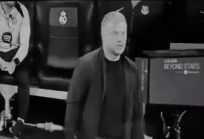 A Man In A Suit Is Standing In Front Of A Beyond Stats Sign . GIF