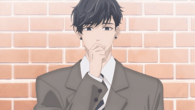 A Man In A Suit Is Standing In Front Of A Brick Wall With His Hand On His Chin GIF