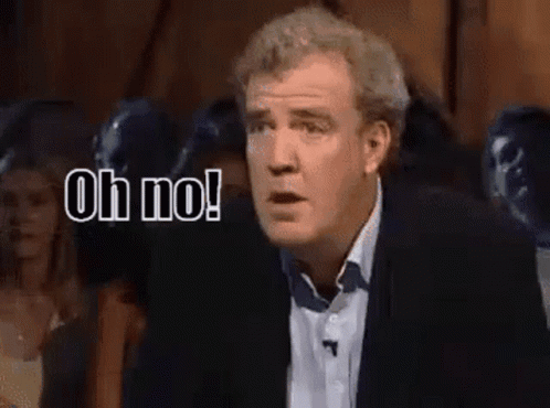 A Man In A Suit Is Standing In Front Of A Crowd And Saying Oh No ! GIF