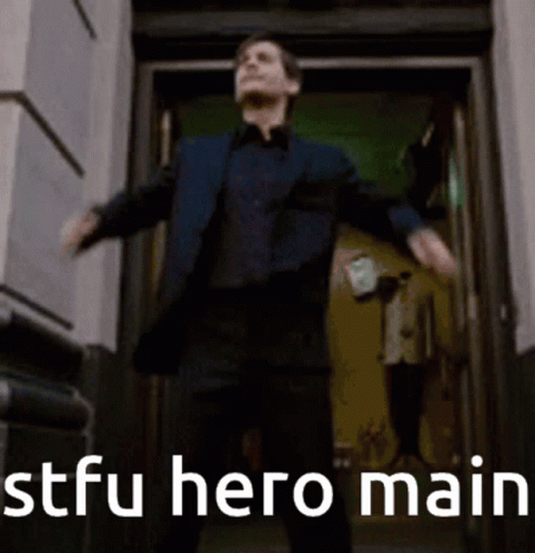 A Man In A Suit Is Standing In Front Of A Door With His Arms Outstretched And The Words Stfu Hero Main Behind Him GIF