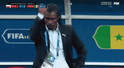 A Man In A Suit Is Standing In Front Of A Fifa Logo GIF