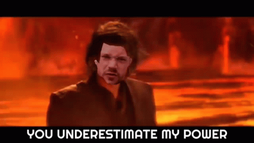 A Man In A Suit Is Standing In Front Of A Fire With The Words `` You Underestimate My Power '' Written Above Him . GIF
