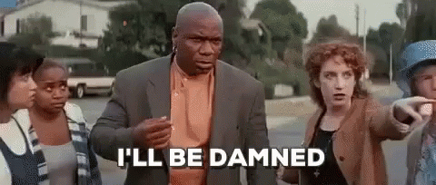 A Man In A Suit Is Standing In Front Of A Group Of People And Talking To Them . GIF