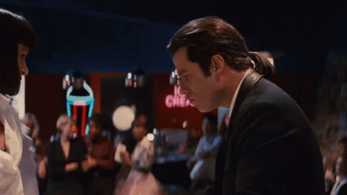 A Man In A Suit Is Standing In Front Of A Neon Sign That Says Ice Cream GIF