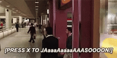 A Man In A Suit Is Standing In Front Of A Phone Booth That Says Press X To Jaaaa GIF