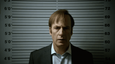 A Man In A Suit Is Standing In Front Of A Police Lineup That Shows His Height At 6 ' 0 " GIF