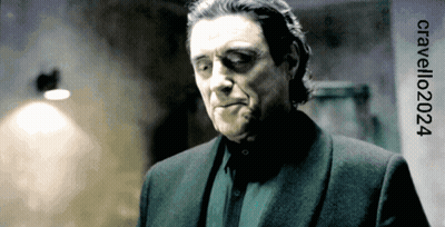 A Man In A Suit Is Standing In Front Of A Sign That Says Cavelli202024 GIF