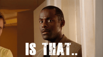 A Man In A Suit Is Standing In Front Of A Sign That Says " Is That " GIF
