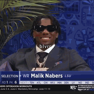 A Man In A Suit Is Standing In Front Of A Sign That Says Next Gen Stats GIF