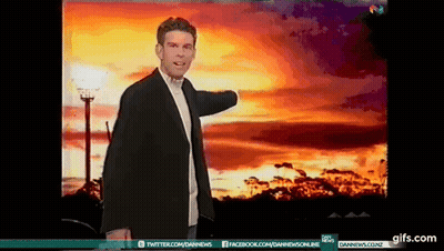 A Man In A Suit Is Standing In Front Of A Sunset With A Twitter And Facebook Icon GIF