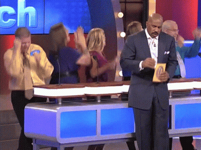 A Man In A Suit Is Standing In Front Of A Table With A Sign That Says ' Ch ' On It GIF